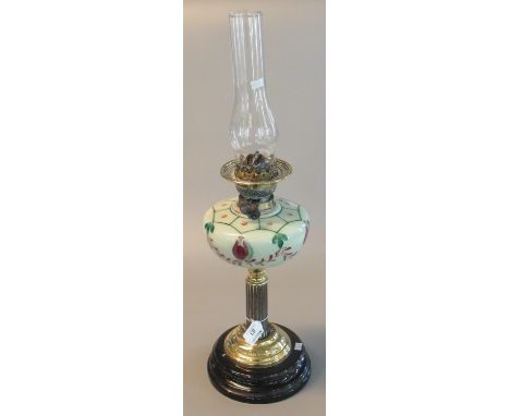 Early 20th century brass double burner oil lamp with painted ceramic reservoir, brass column, and black ceramic base with a c