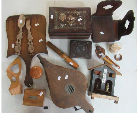 Box containing various wooden items including bellows, book ends, wooden boxes, ornately carved salad servers, thermometer et