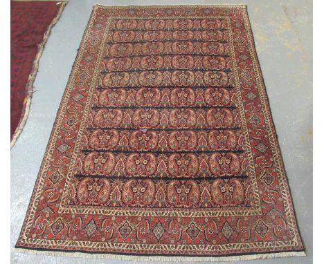 Middle Eastern design carpet on a red and blue ground with central medallions of foliage flanked by petal boarders. 310 x 207