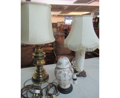 Three lamps to include: one with brass base and cream shade, one white ceramic lamp base with gargoyle decoration and cream s