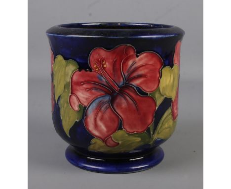 A Moorcroft pottery jardiniere decorated in the Hibiscus design. Impressed factory mark and signed to base. Height 17cm.  Has