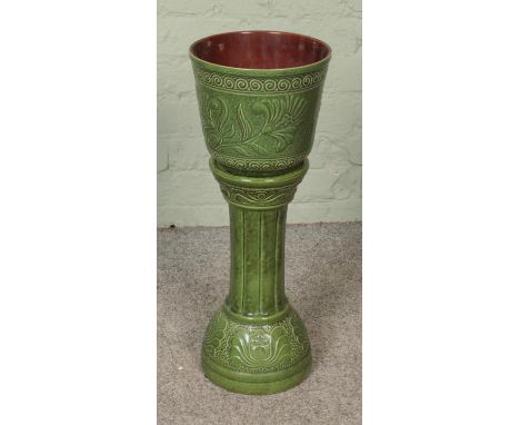 A West German pottery jardiniere/plant stand depicting floral motifs.  Small chip to rim of planter. Both pieces crazed.