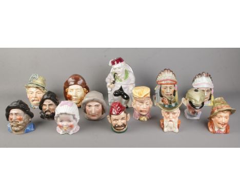 Fourteen assorted ceramic tobacco jars, to include baby, pipe smoking, Majolica style and souvenir examples.  