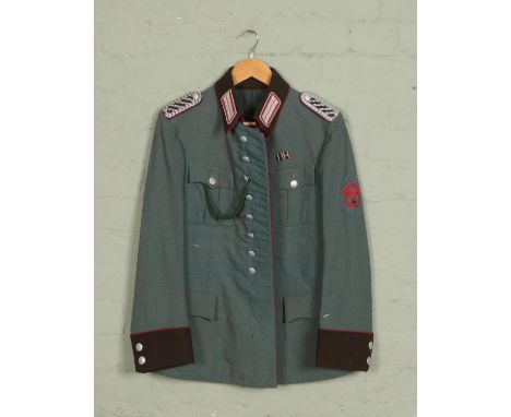 A German Police Service Tunic with green wool rayon blend and two pleated patch breast pockets and two hip pockets with scall