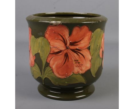 A Moorcroft pottery jardiniere decorated in the Hibiscus design. Impressed factory mark and signed to base. Height 17.5cm.  H