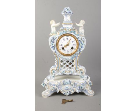 A Nineteenth Century French blue and white ceramic mantle clock on stand, depicting two cherubs surrounded by floral decorati