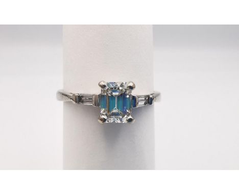 An Art Deco style 18ct white gold modern emerald cut diamond flanked solitaire ring. Set to centre with a emerald cut diamond