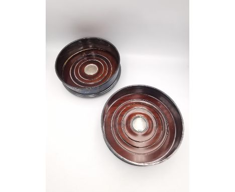 A pair of 20th century silver and oak wine coasters  by Richard Carr. Hallmarked:RC, Sheffield, 1997. D.10.5cm 