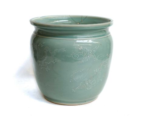 A Chinese celadon glazed porcelain jardiniere with white enamel decoration, depicting dragons and cloud scrolls, underglaze s