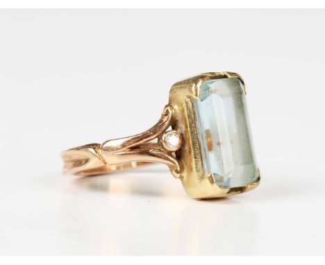 A gold ring, mounted with a rectangular step cut aquamarine between diamond single stone shoulders, unmarked, weight 5.7g, ri