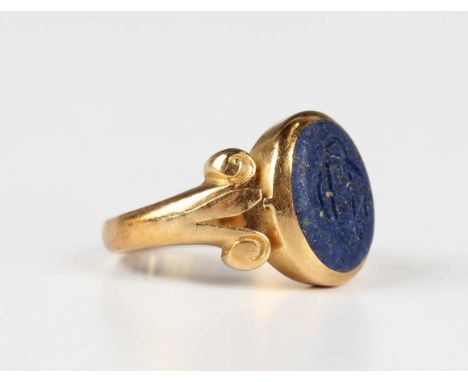 A gold and lapis lazuli signet ring, monogram engraved, with scroll decorated shoulders, detailed '18ct', weight 3.5g, ring s