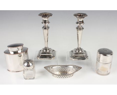 A pair of George V silver candlesticks, each with an octagonal sconce above a tapering octagonal stem and stepped square base