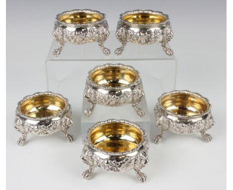 A harlequin set of six George II and III silver circular salt cellars, each with everted gadrooned rim and gilt interior, the