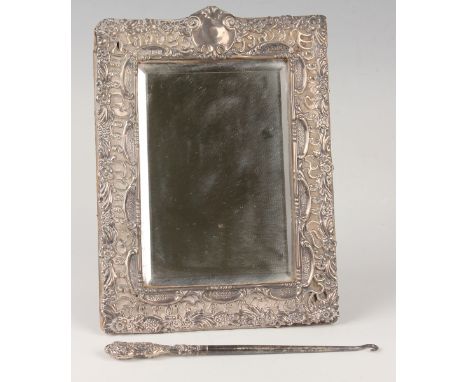 An Edwardian silver mounted rectangular dressing table mirror, embossed with flowers and scrolls, Birmingham 1901 by Abraham 