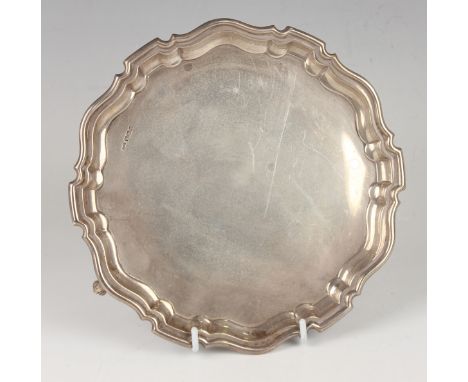 A George V silver circular card salver with piecrust rim, on scroll feet, Sheffield 1924 by Brook &amp; Son, weight 275.4g, d