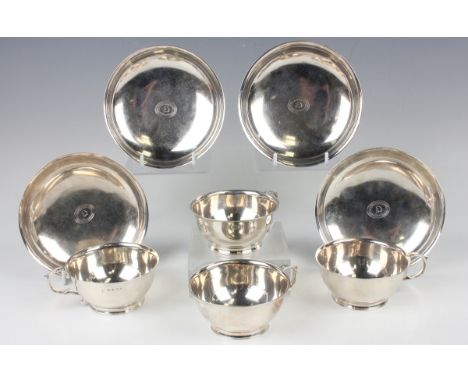A set of four George III silver teacups and saucers, each cup with foliate capped scroll handle, each piece engraved with an 