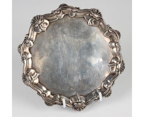 A George III silver card salver with raised scroll and scalloped rim, on three hoof feet, London 1767 by John Carter II, weig
