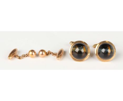 A pair of gold mounted circular tiger's eye cufflinks of hemispherical form, with folding oval bar fittings, detailed '9ct', 