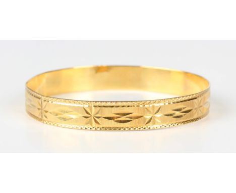 A Middle Eastern gold oval bangle with facet cut decoration, weight 18.9g, inside width 6.5cm.Buyer’s Premium 29.4% (includin