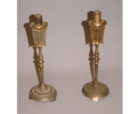 A pair of gilt metal table-lighters, each raised on a columnar support and circular base. Each approximately 235mm tall CONDI