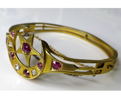 A Victorian 15ct gold ruby and diamond bangle with crescent moon and five pointed star design, composed of seven cushion cut 