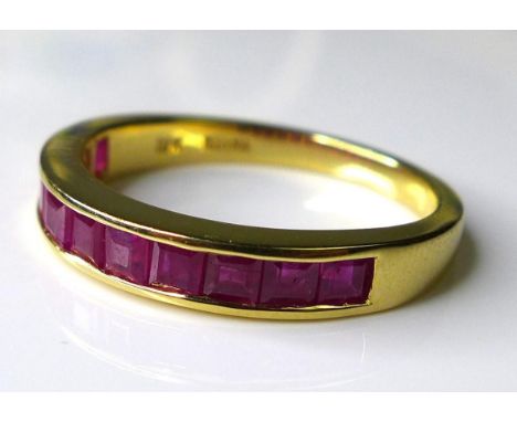 An 18ct gold and ruby half eternity ring, set with eleven square cut rubies, each stone approximately 2 by 2mm, size P, 3.7g.