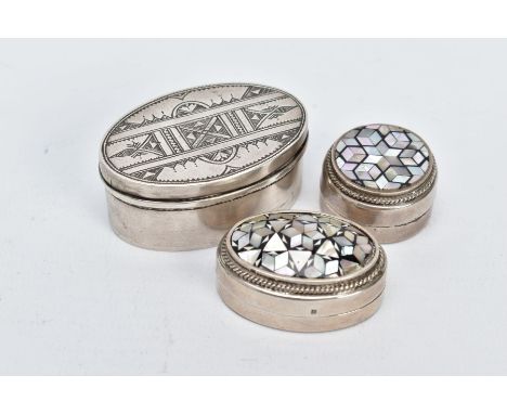 TWO EGYPTIAN SILVER PILL BOXES AND A WHITE METAL TRINKET BOX, two pill boxes of a circular and oval form, each set with black