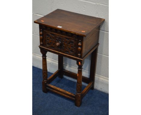 A REPRODUCTION OAK LAMP TABLE, single drawer with a stylised front, on cylindrical tapering front legs, united by stretchers,