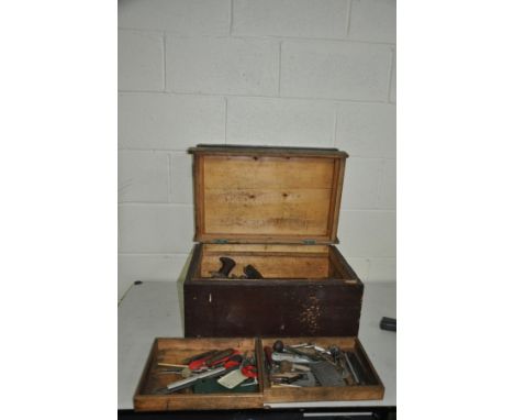 A STAINED PINE TOOLBOX with double opening and two trays containing woodworking tools including five wooden planes, rules, so