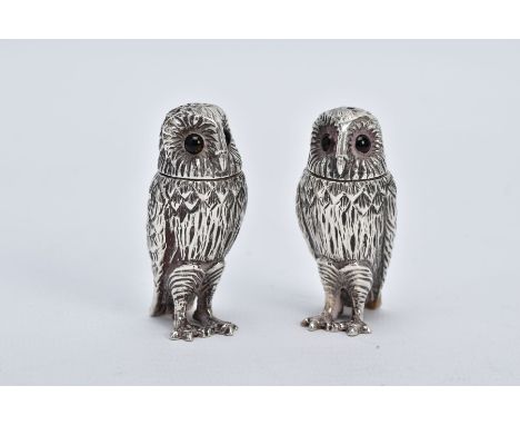 A PAIR OF SILVER SALT AND PEPPER POTS, each in the form of an owl, realistically modelled standing upright, set with glass ey