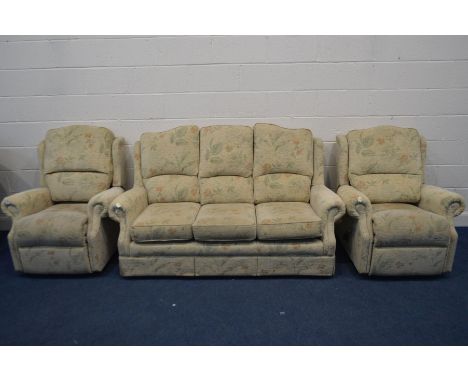 A FLORAL UPHOLSTERED THREE PIECE LOUNGE SUITE, comprising a three seater settee and two manual reclining armchairs (3)