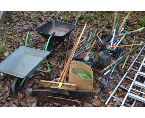A COLLECTION OF VARIOUS GARDEN TOOLS, to include two metal wheelbarrows, a bundle of various sized yard brushes, a bundle of 