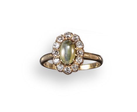 A chrysoberyl cat's eye and diamond cluster ring, the oval-shaped cat's eye with strong chatoyancy set within a surround of t