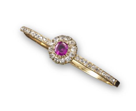 A late Victorian ruby and diamond hinged bangle, centred with a cushion-shaped ruby cluster within a surround of cushion-shap