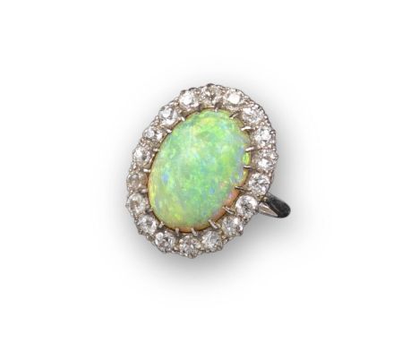 An opal and diamond cluster ring, the oval-shaped cabochon opal (crazed) set within a surround of eighteen circular-cut diamo