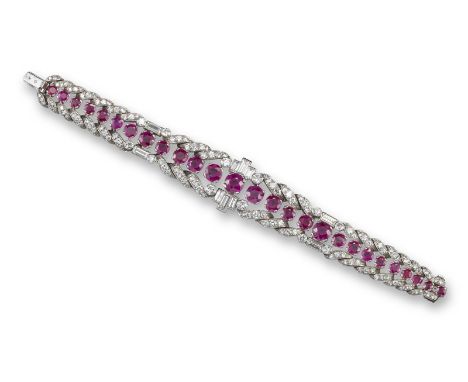 A ruby and diamond bracelet, set with a line of graduated circular-cut rubies within a border of scrolling diamond sections, 