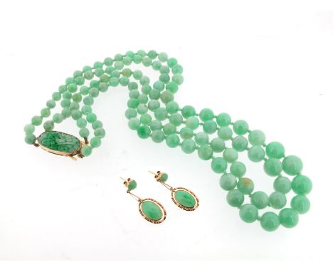 A two-row jade bead necklace, the beads graduate from 5.64 to 10.23mm with a foliate carved jade clasp set in yellow gold, 51