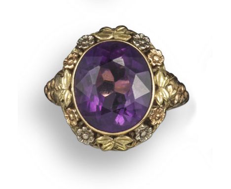 An amethyst foliate cluster ring, the oval-shaped amethyst is set within a surround of foliate carved decoration, in gold, Au