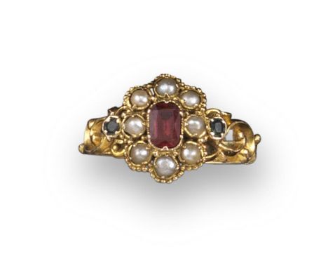 A Victorian ruby and seed pearl cluster ring, set with tourmalines to each shoulder on scroll carved yellow gold shank, glaze