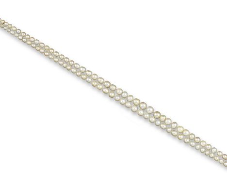 A two-row natural pearl necklace, the pearls graduate from 3.1 to 7.5mm, set with a ruby and diamond cluster clasp in platinu