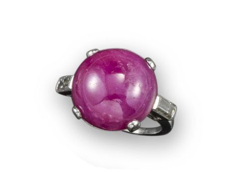 A circular cabochon ruby and diamond ring, the ruby set with two baguette-shaped shoulder diamonds in white gold, size L