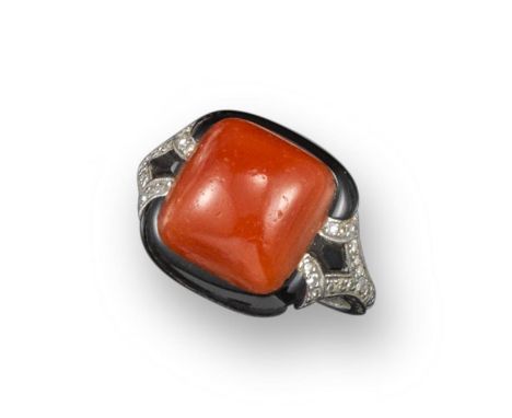 An Art Deco coral, onyx and diamond-set ring, the sugarloaf-shaped coral is set within a surround of black onyx and small dia