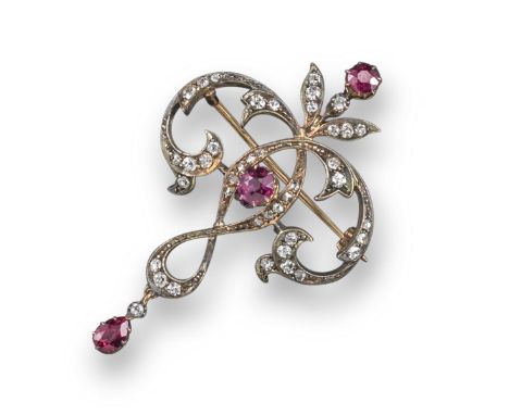 An Art Nouveau ruby and diamond brooch, set with three rubies and graduated old cushion-shaped and rose-cut diamonds in silve