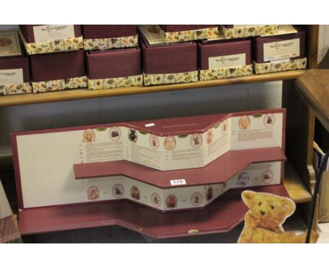 A complete collection of 10 ceramic Steiff teddy bears by Ensesco, on a display case 