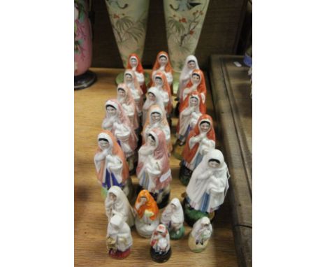 A collection of 21 German ceramic figures including a lady holding a lamp 