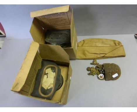 Two boxed gas masks, a forage cap and a pouch of vintage military badges etc