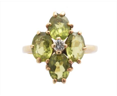 A 9ct gold peridot and diamond dress ring, designed as a brilliant cut diamond within an oval shape peridot quatrefoil surrou