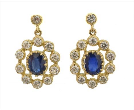 A pair of sapphire and diamond earrings, each designed as an oval shape sapphire within a brilliant cut diamond openwork surr