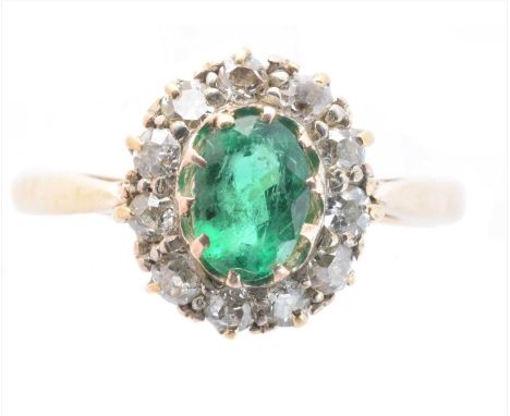 A 9ct gold emerald and diamond cluster ring, the oval shape emerald within an old cut diamond surround, hallmarks for Birming