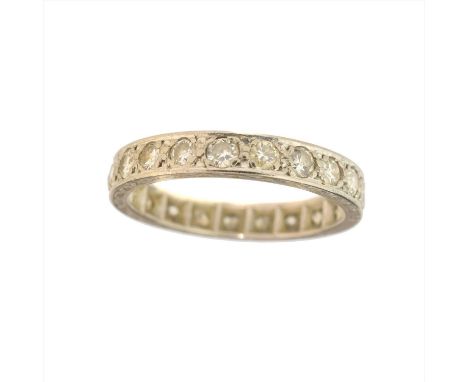 A diamond eternity ring, the circular cut diamond line with geometric detailed gallery, stamped 18ct, estimated total diamond